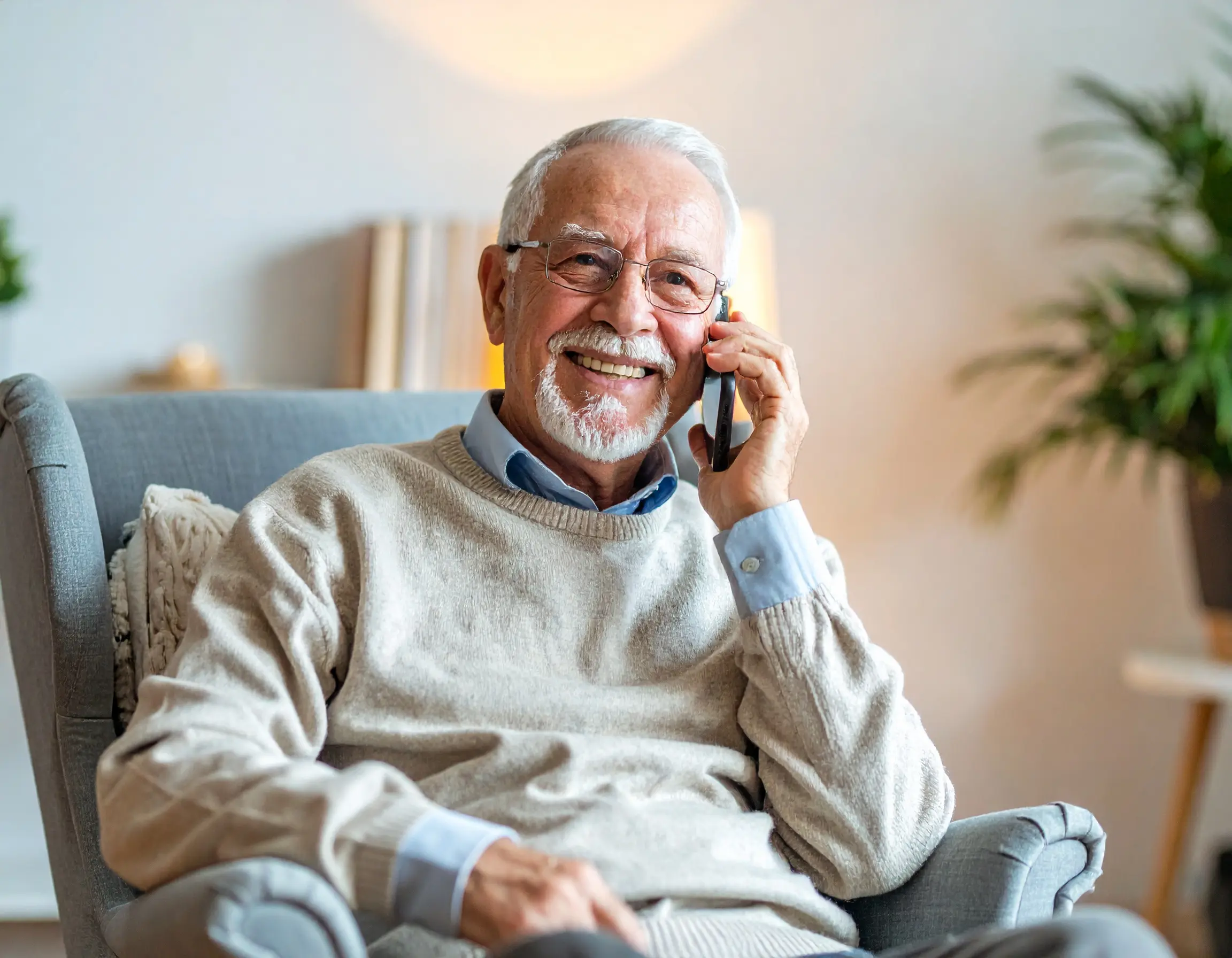 Elderly woman smiling while receiving daily wellness check-in call from Positive Check