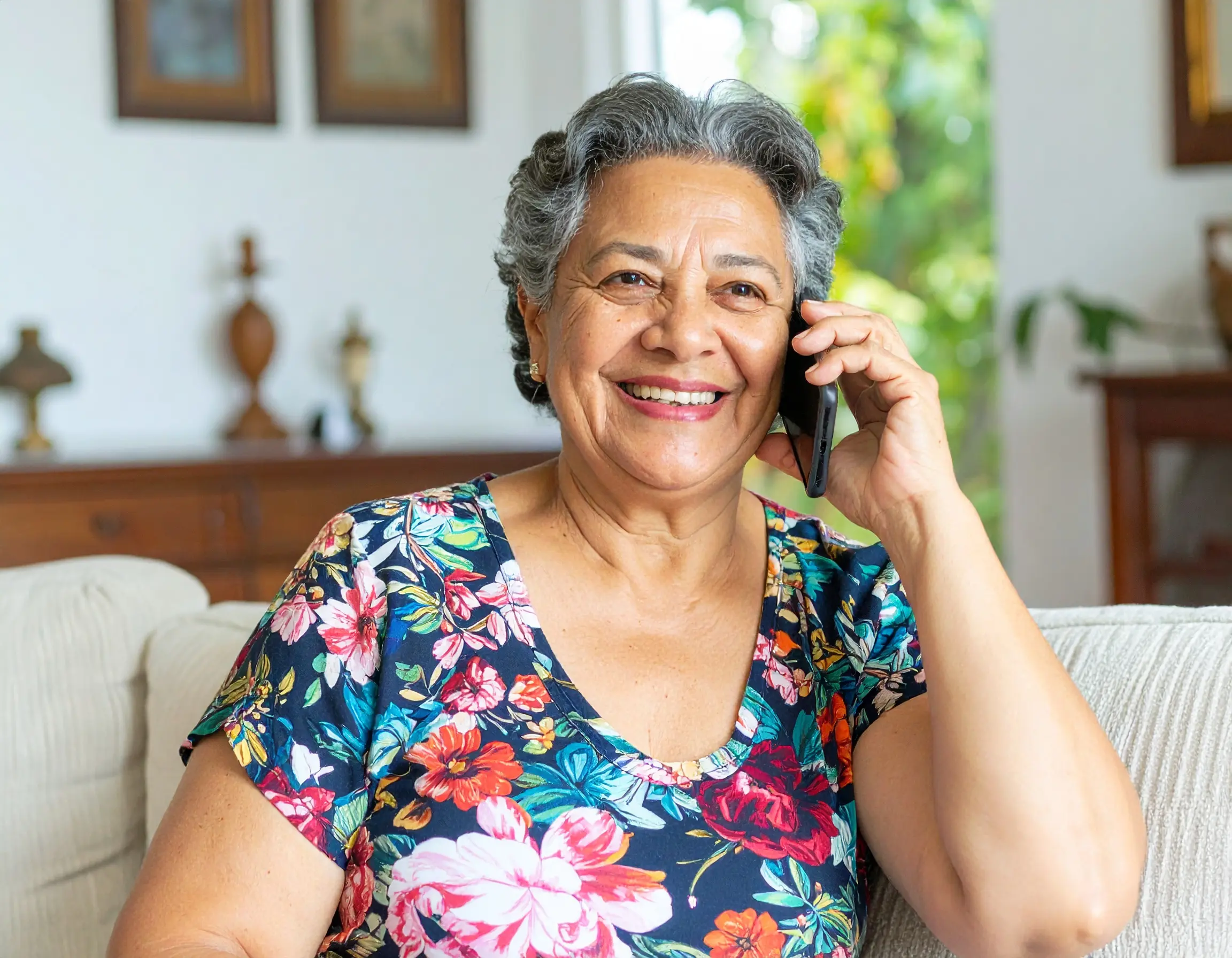 Senior woman enjoying daily wellness call with AI companion Lola